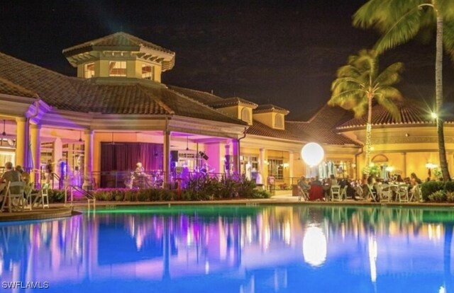 view of pool at twilight