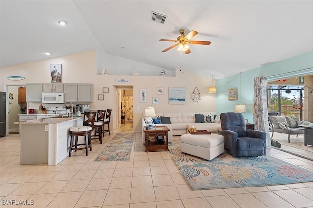 living room with ceiling fan, light tile patterned flooring, and high vaulted ceiling