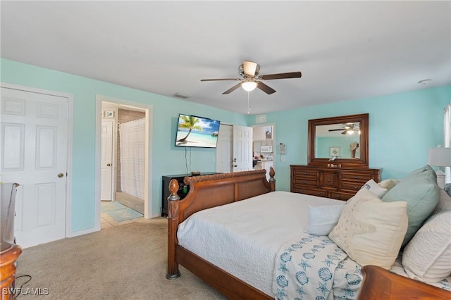 carpeted bedroom with ceiling fan and connected bathroom