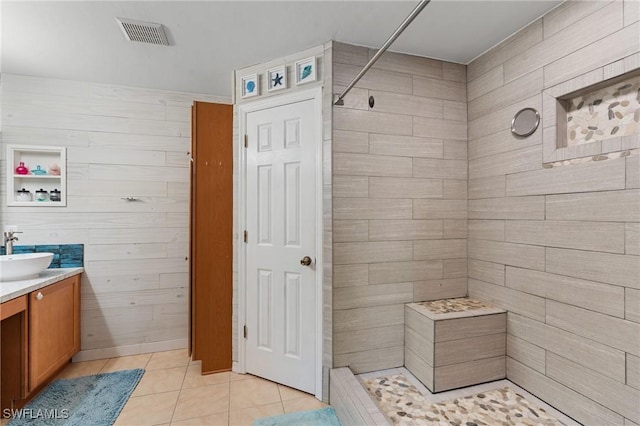 bathroom with a shower, vanity, and tile patterned flooring