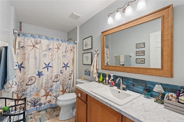 bathroom with toilet, vanity, tile patterned flooring, and walk in shower