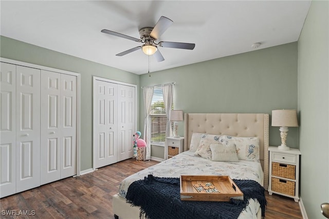 bedroom featuring ceiling fan, two closets, and dark wood-type flooring