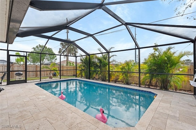 view of pool with glass enclosure and a patio area