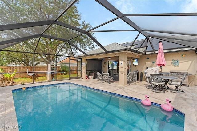 view of swimming pool featuring glass enclosure and a patio area