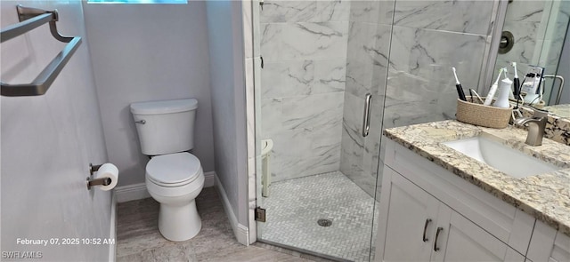 bathroom with vanity, a shower with door, and toilet