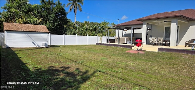 view of yard featuring a shed, ceiling fan, and a patio area