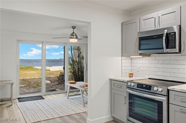 kitchen with a water view, appliances with stainless steel finishes, and gray cabinets