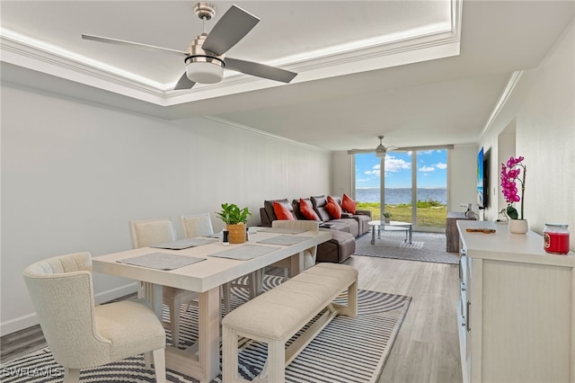 dining area with light hardwood / wood-style flooring, a wall of windows, ornamental molding, and ceiling fan