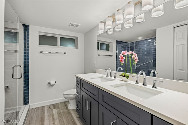 bathroom featuring hardwood / wood-style flooring, vanity, an enclosed shower, and toilet