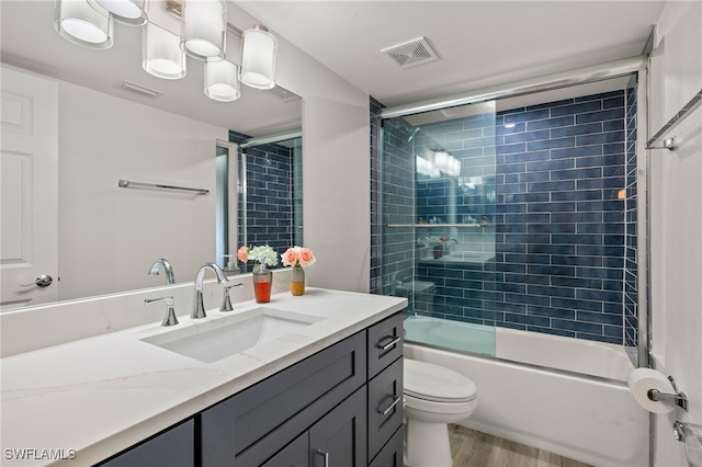 full bathroom with toilet, vanity, shower / bath combination with glass door, and hardwood / wood-style floors