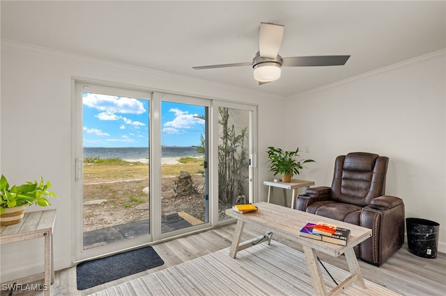 sitting room featuring a water view, ornamental molding, and light hardwood / wood-style floors