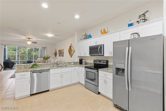 kitchen featuring stainless steel appliances, sink, white cabinets, and kitchen peninsula