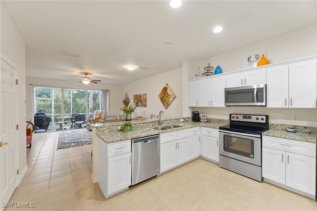 kitchen featuring sink, stainless steel appliances, kitchen peninsula, and white cabinets