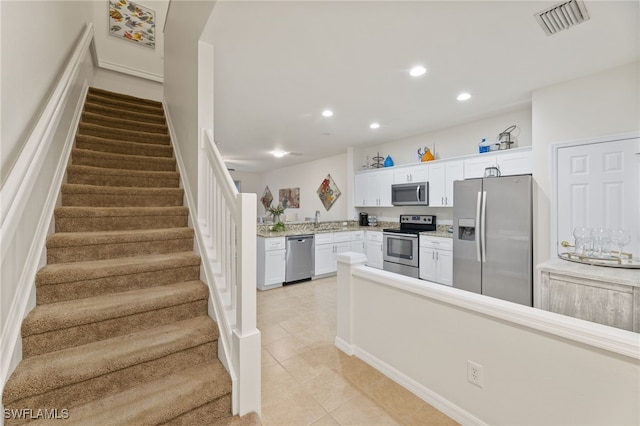 kitchen with white cabinetry, sink, stainless steel appliances, and light tile patterned flooring