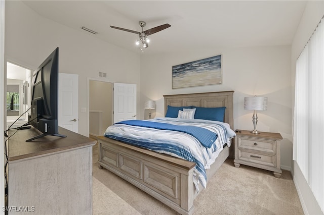 bedroom featuring multiple windows, lofted ceiling, light colored carpet, and ceiling fan