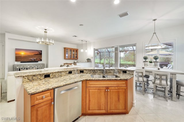 kitchen with light stone counters, sink, pendant lighting, and dishwasher