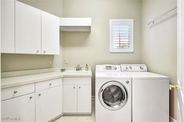 clothes washing area with sink, light tile patterned floors, cabinets, and independent washer and dryer