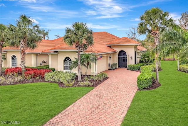 mediterranean / spanish-style house with a garage and a front yard