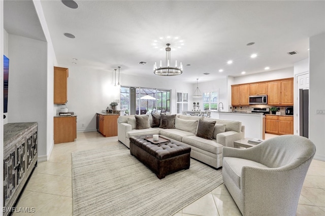 tiled living room featuring sink and a notable chandelier