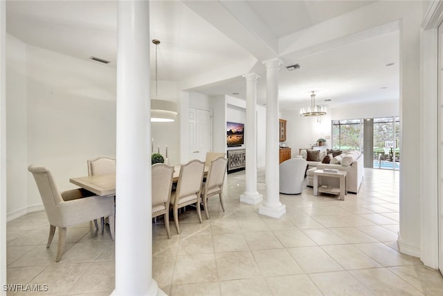 dining space featuring light tile patterned flooring, an inviting chandelier, and ornate columns