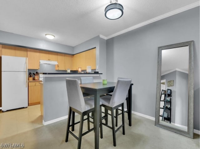 dining area with a textured ceiling and ornamental molding