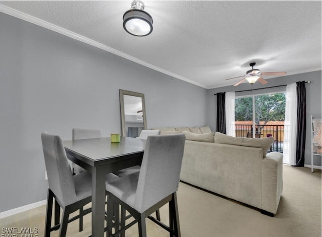 dining area featuring a textured ceiling, ceiling fan, and crown molding