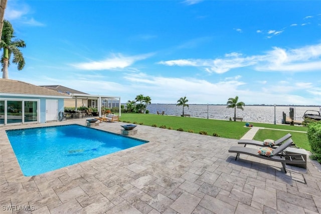 view of pool with a water view, a patio area, and a yard