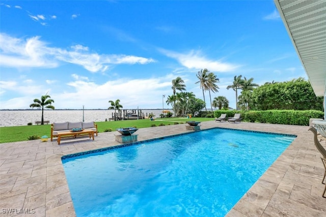 view of pool with a water view, a yard, and a patio