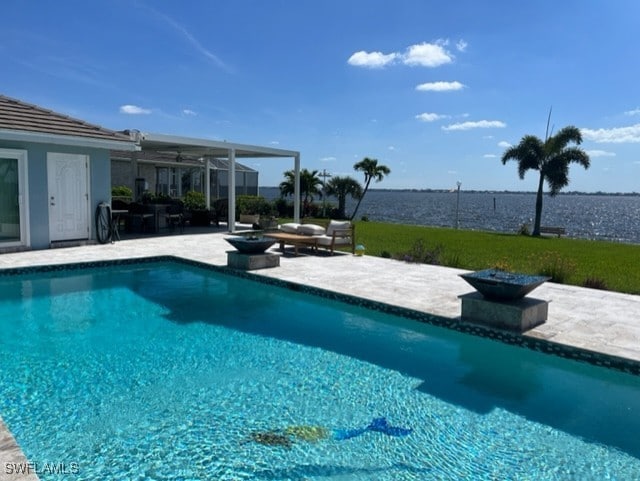 view of pool with a water view and a patio