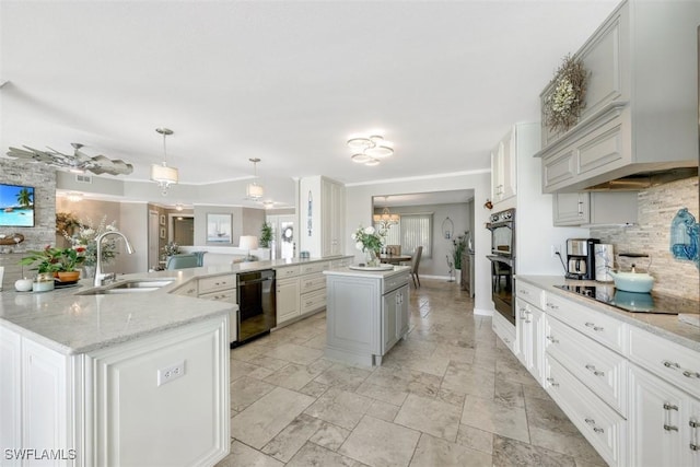 kitchen featuring decorative backsplash, black appliances, a kitchen island with sink, pendant lighting, and sink