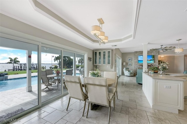 dining space featuring a tray ceiling and sink