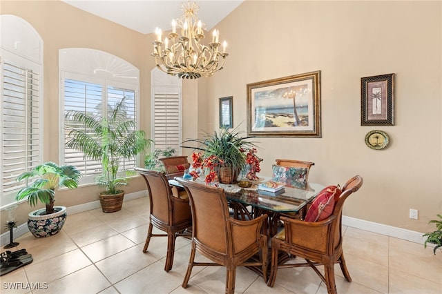 tiled dining space with an inviting chandelier and lofted ceiling