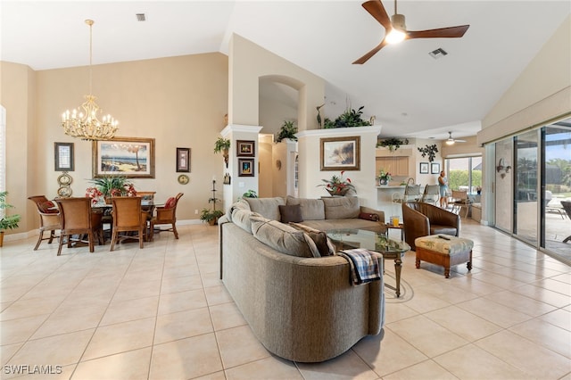 tiled living room with ceiling fan with notable chandelier and lofted ceiling