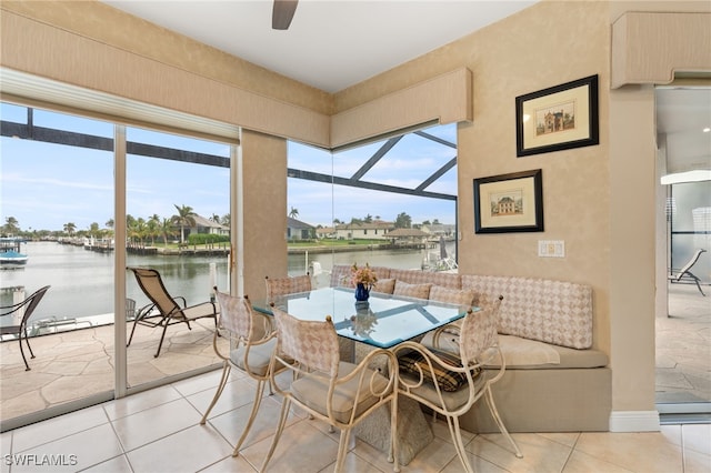 sunroom with a water view and ceiling fan