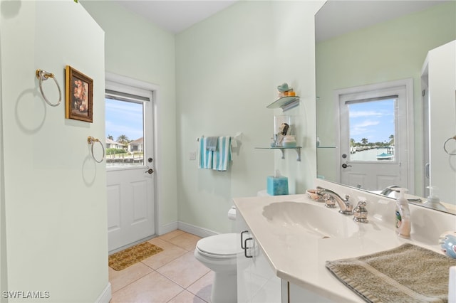 bathroom with toilet, vanity, and tile patterned flooring