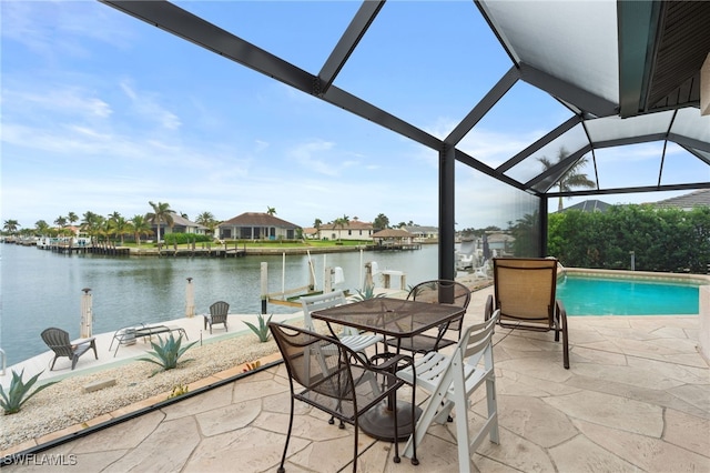 view of patio / terrace featuring a water view, a lanai, and a boat dock