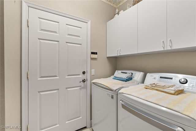 washroom with cabinets and washer and dryer