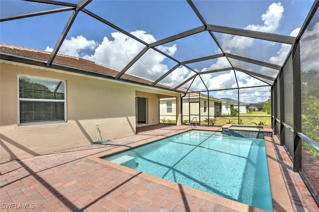 view of swimming pool featuring glass enclosure, a patio area, and an in ground hot tub