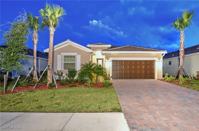 view of front of property featuring a garage and a lawn