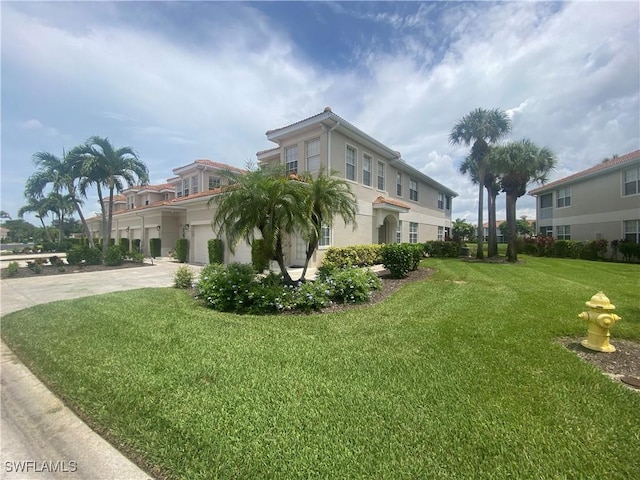 3054 Driftwood Way Unit 4508, Naples, FL 34109 - view of home's exterior featuring a lawn, driveway, a garage, and stucco siding