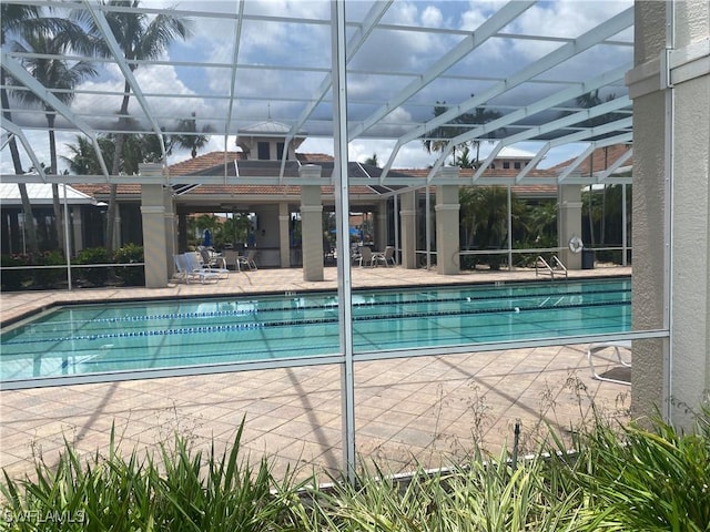 3054 Driftwood Way Unit 4508, Naples, FL 34109 - community pool featuring glass enclosure and a patio area