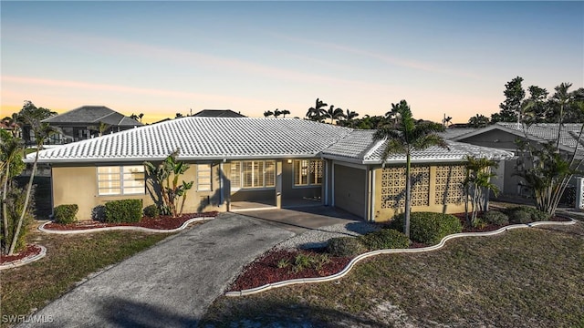 ranch-style house featuring a garage and a lawn