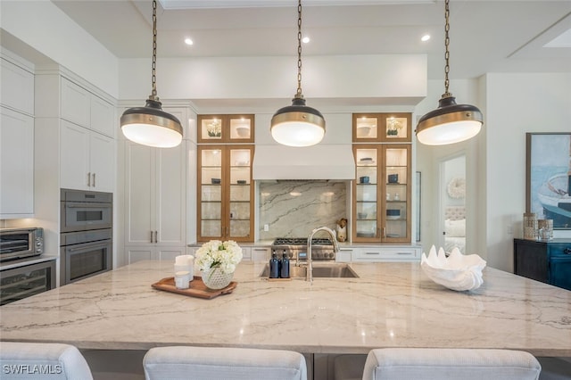 kitchen with hanging light fixtures, a large island, and sink