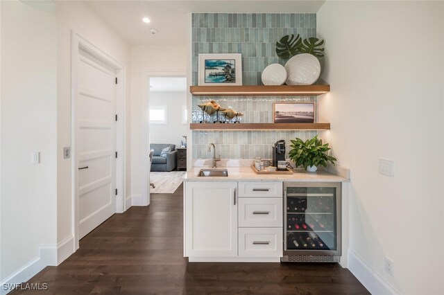 bar featuring white cabinetry, sink, beverage cooler, dark hardwood / wood-style flooring, and backsplash