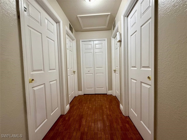 hall featuring a textured ceiling and dark hardwood / wood-style flooring