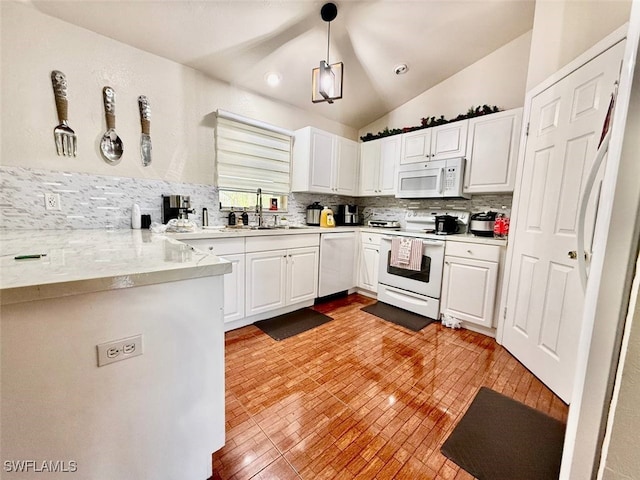 kitchen with lofted ceiling, white cabinetry, pendant lighting, and white appliances