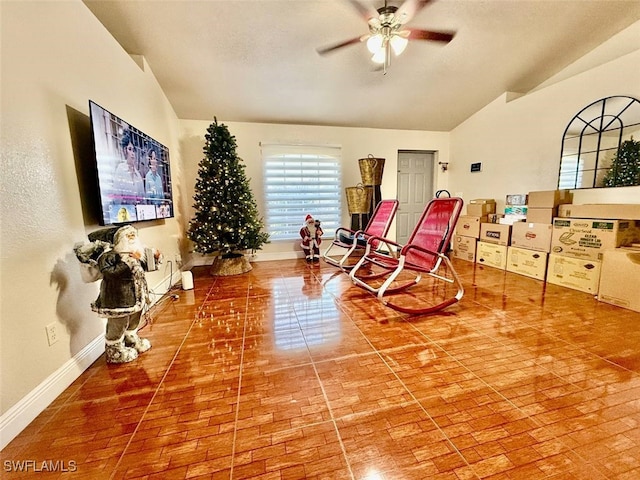 living area featuring ceiling fan and lofted ceiling