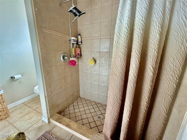 bathroom featuring walk in shower, tile patterned floors, and toilet