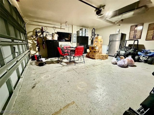 garage with stainless steel fridge and a garage door opener