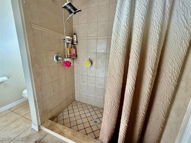 bathroom featuring curtained shower, tile patterned floors, and toilet